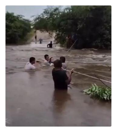 Moradores atravessam trecho inundado por enchente usando corda em Forquilha, no Ceará